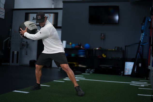 Coach Joey D preparing to throw a soft-shell medicine ball