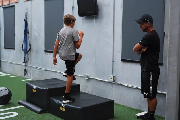 Coach watching young man do step-ups